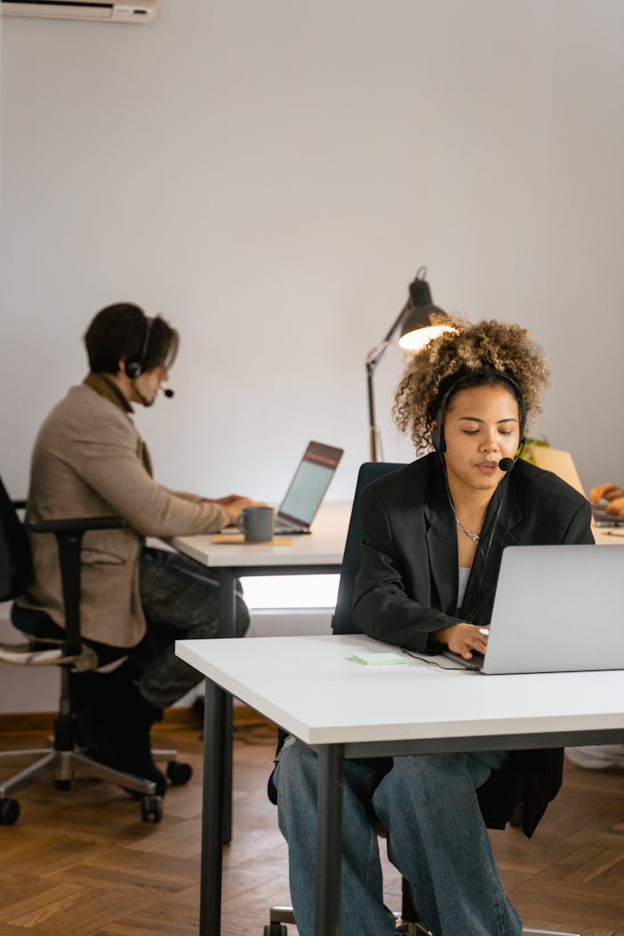Two call center agents working diligently in a modern office environment.