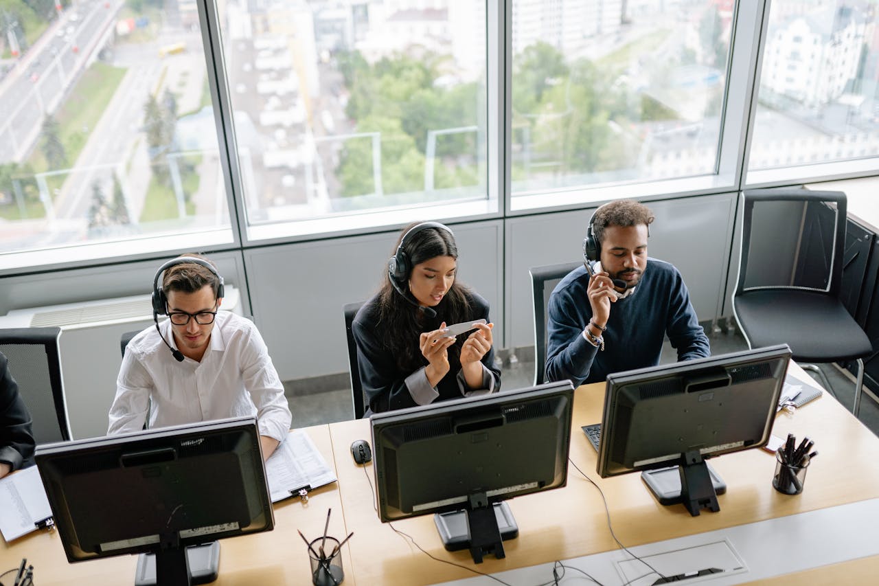 Diverse call center team working in a bright office space with a city view.